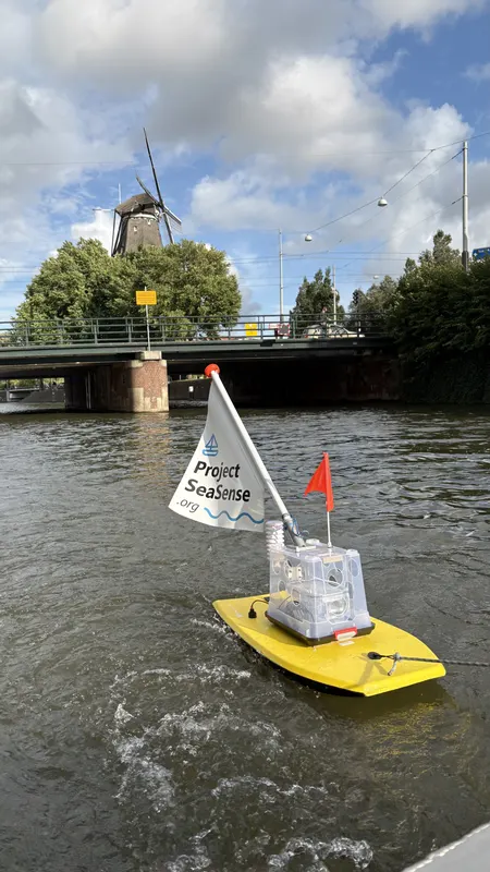 The prototype on an Amsterdam canal, with a windmill and bridge behind it
